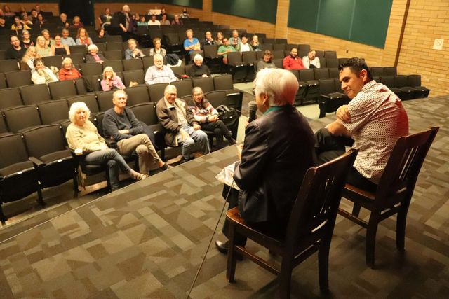 Two people seated at the front of the auditorium during a question and answer session