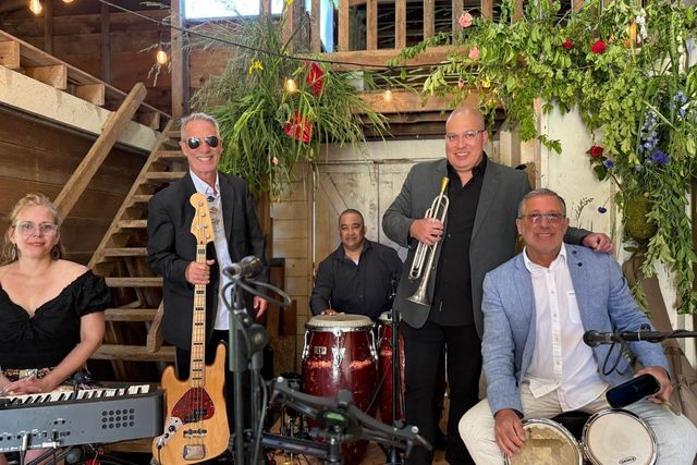 A band of five musicians with congas, double bass, keyboard and guitar